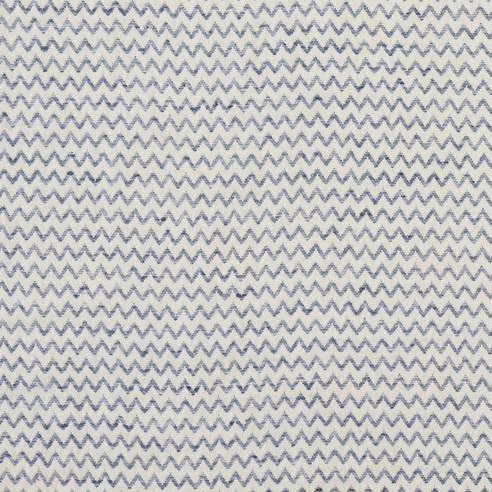 White fabric with blue zigzag chevron pattern; lightweight woven textile for apparel or decor.