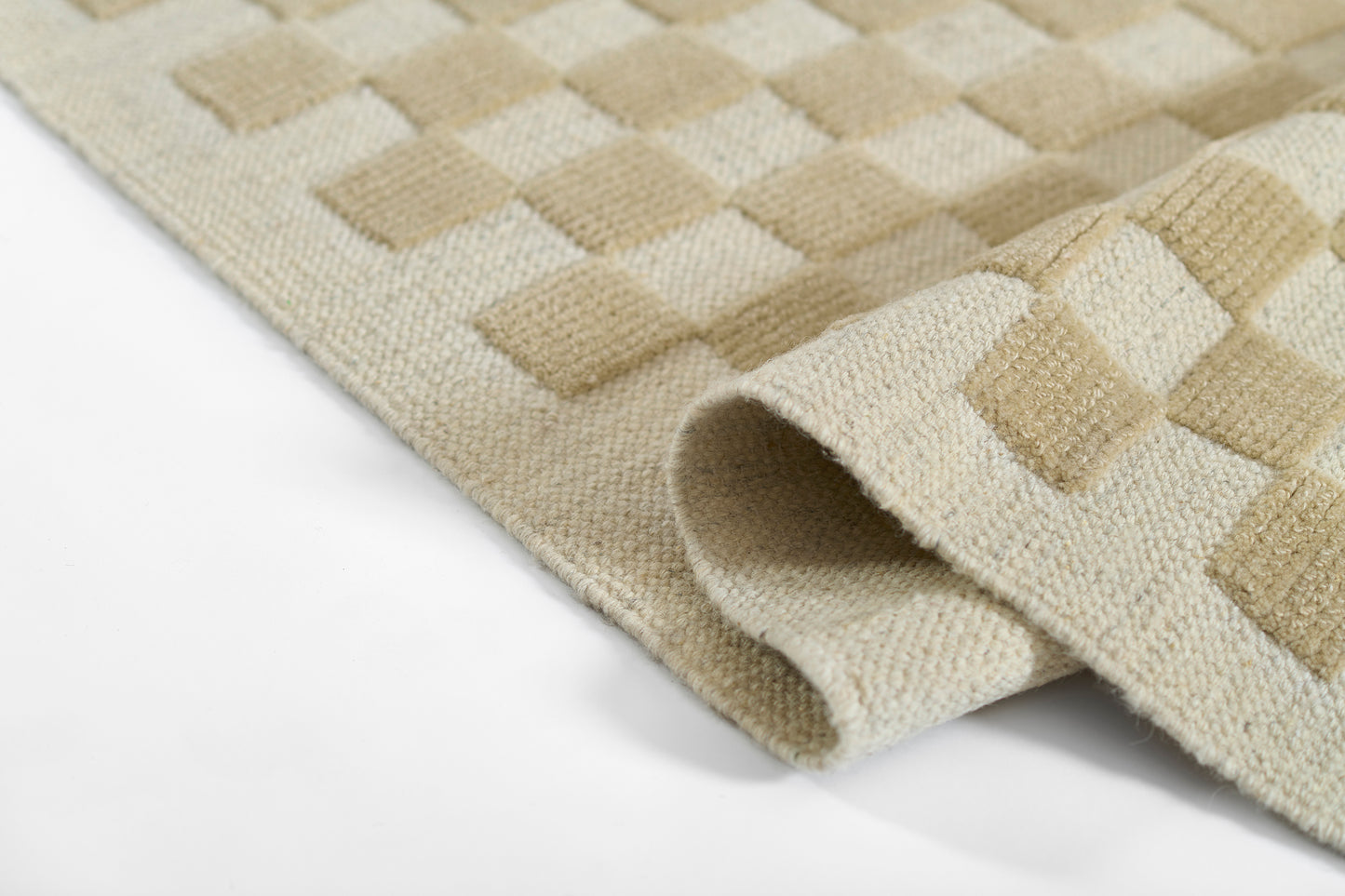 Beige and cream checker woven rug, folded corner, soft textured floor decor.