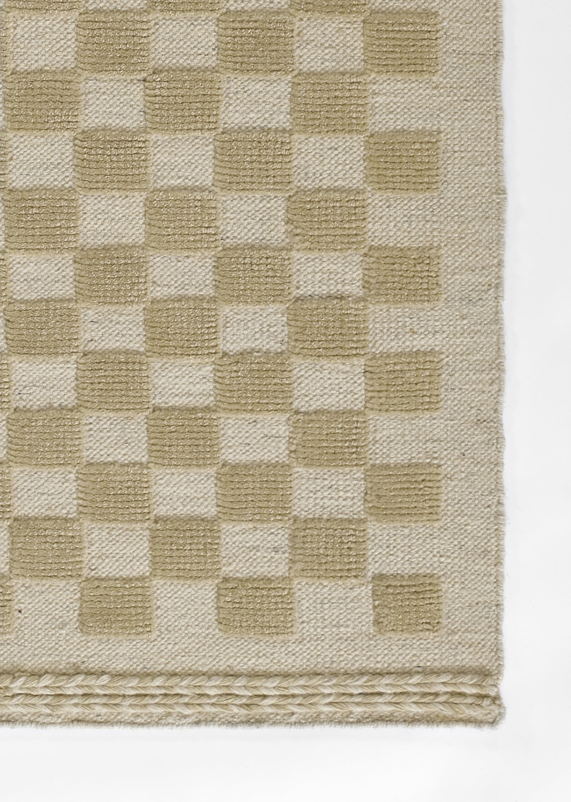 Beige and cream checkerboard woven rug with braided border fringe.