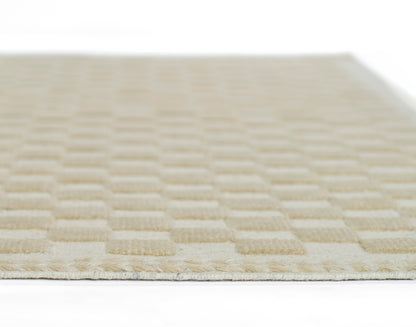 Beige rectangular rug with a raised square checkerboard texture and soft plush feel.
