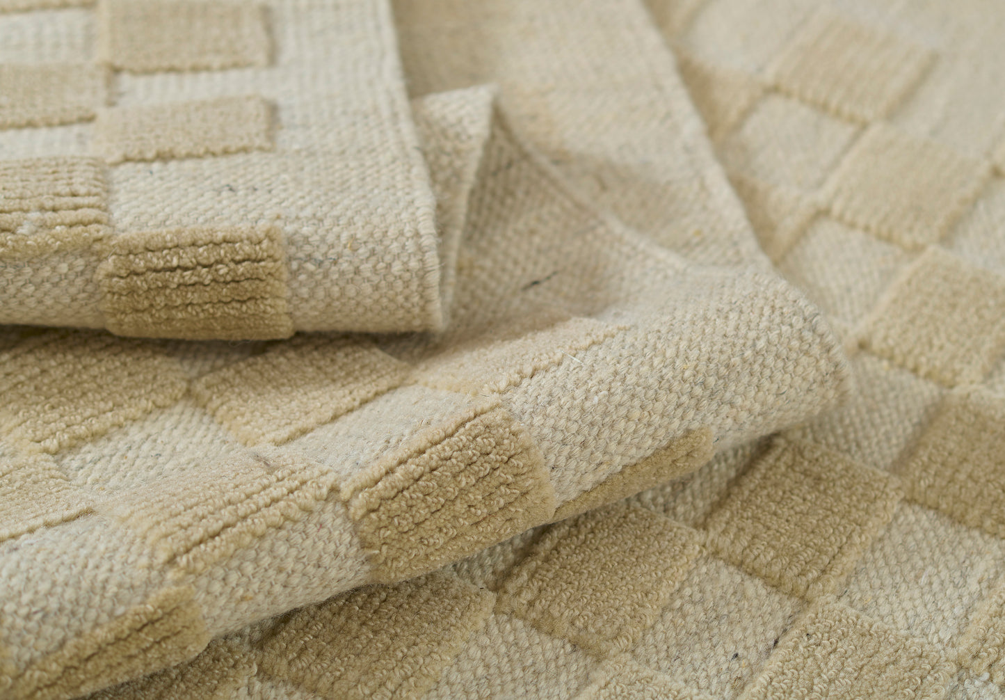 Beige rug with a cream checkerboard pattern; plush woven area rug, 9' x 12'.