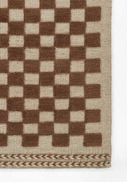 Beige woven rug with a brown checkerboard pattern and a decorative braided edge along the bottom.