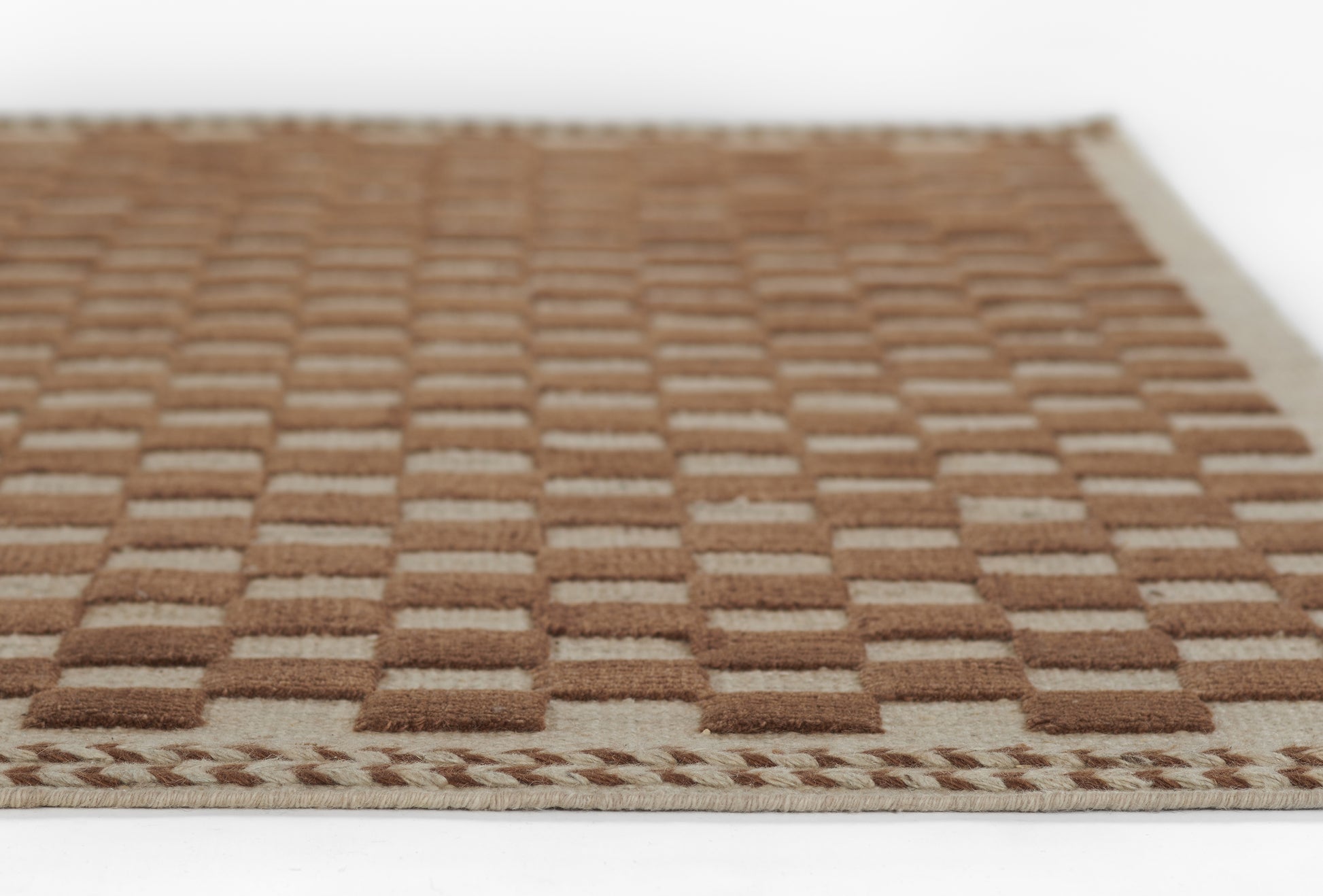 Brown checkerboard woven rug with beige border; rustic jute/sisal style runner rug.