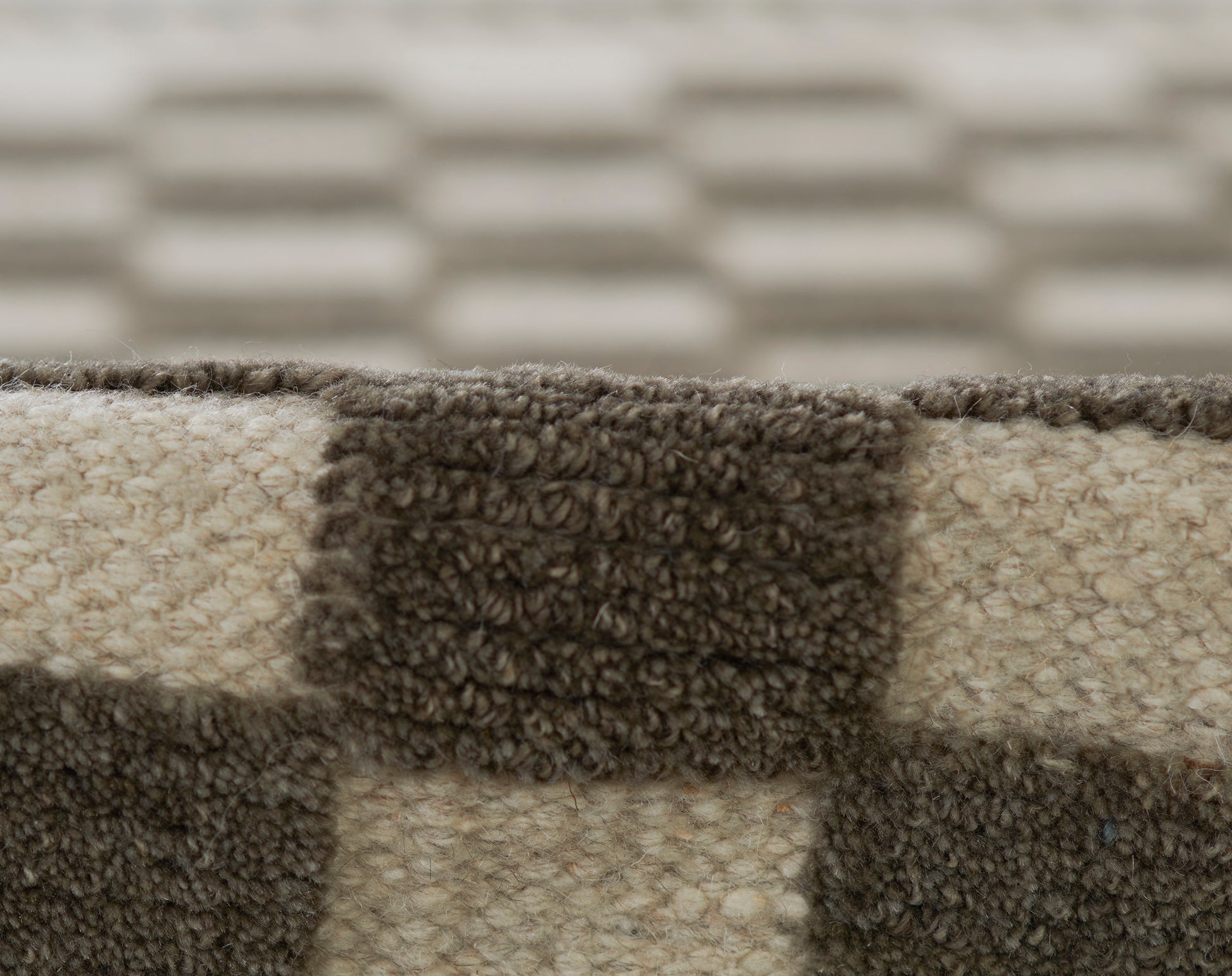 Close-up of a brown and beige plaid rug with dense boucle loop pile and chunky texture.