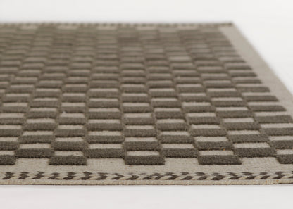 Gray-taupe tufted grid floor mat with raised square pattern and chevron border, ideal for entryways.