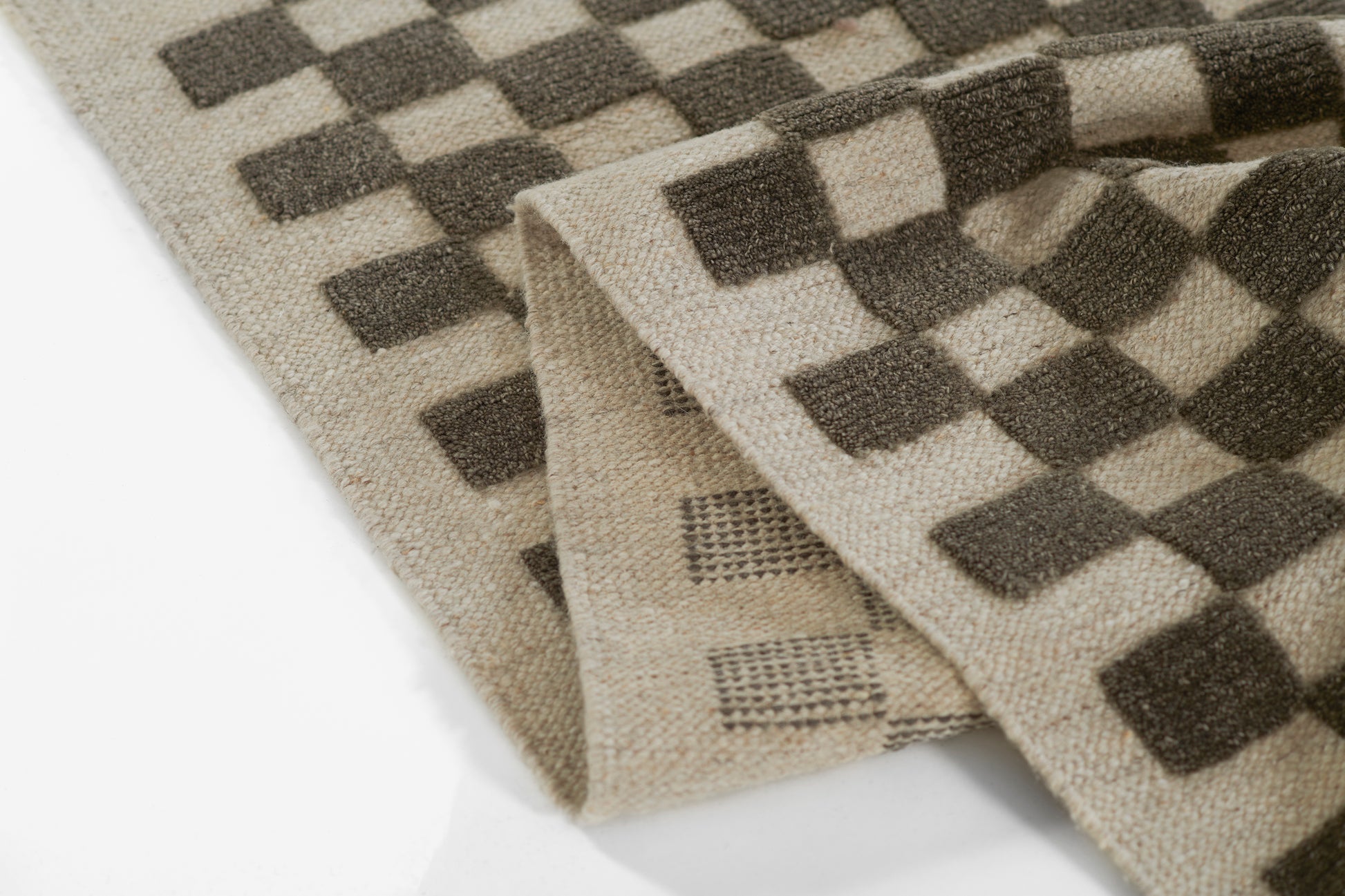 Beige woven rug with dark brown checkerboard pattern, soft wool blend, 8' x 10'.