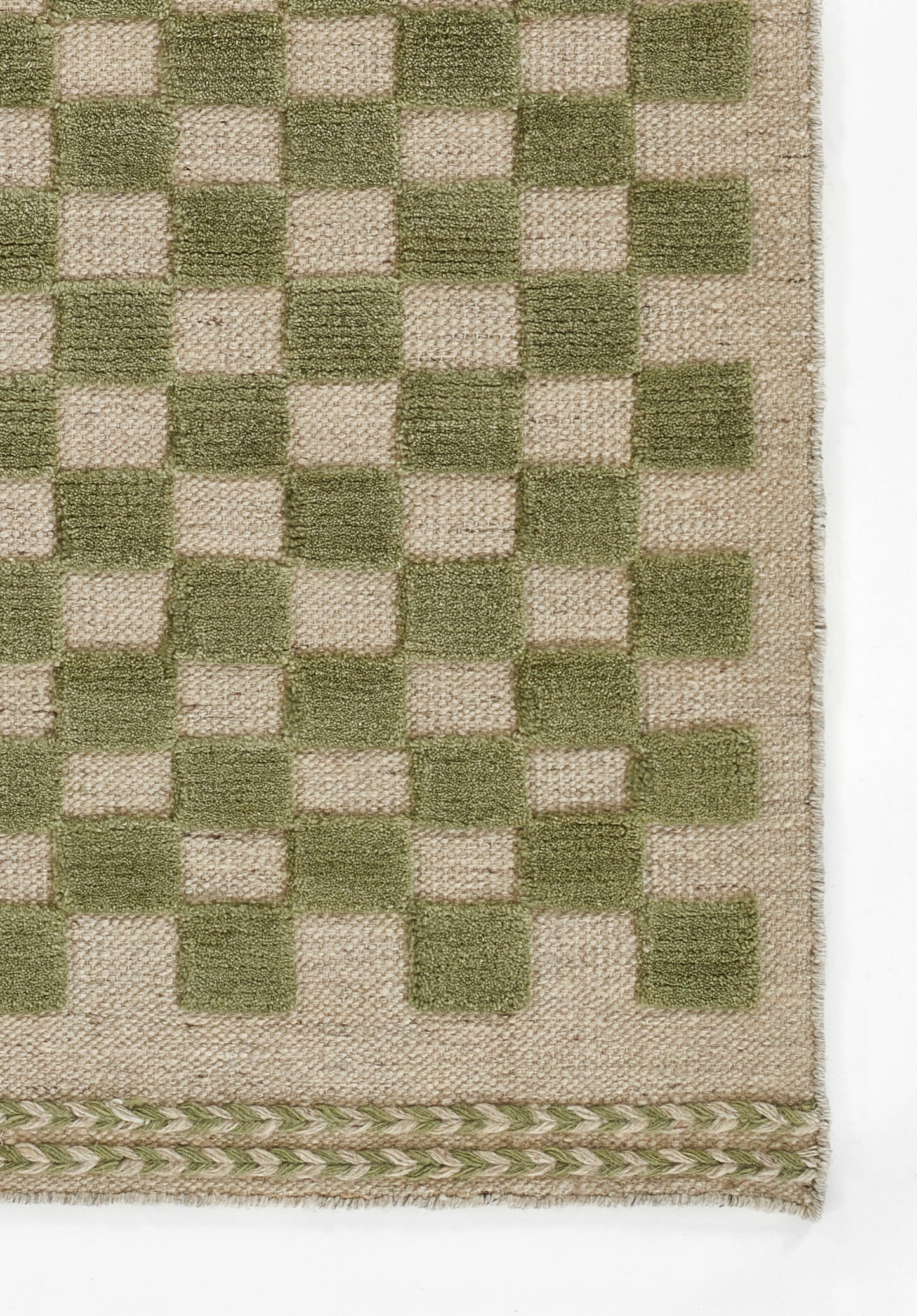 Woven rug with olive green and natural beige checkerboard pattern; textured fabric with a braided border along the bottom edge.