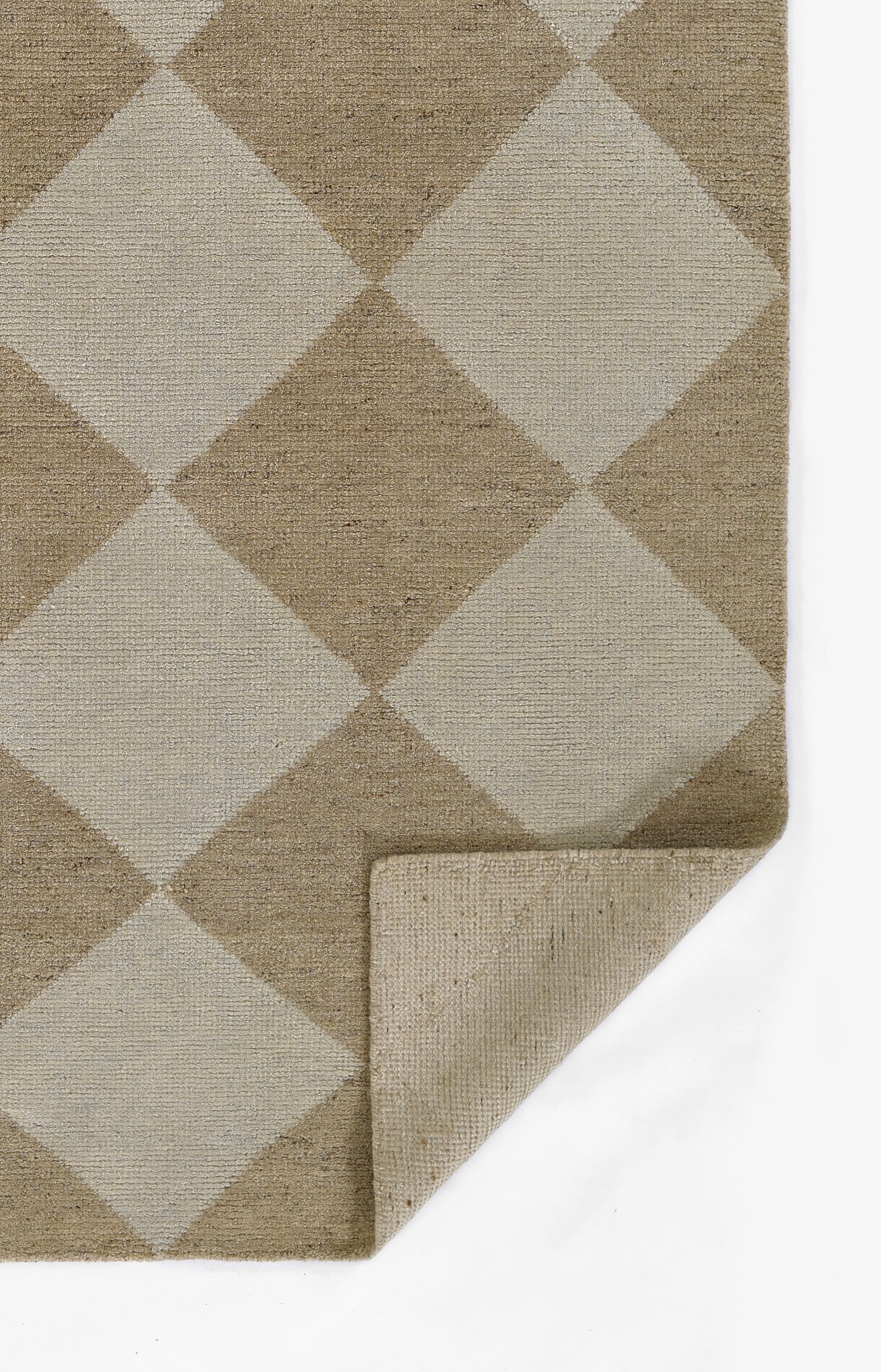 Woven natural fiber rug in beige and taupe diamond pattern; rectangular with a folded corner.