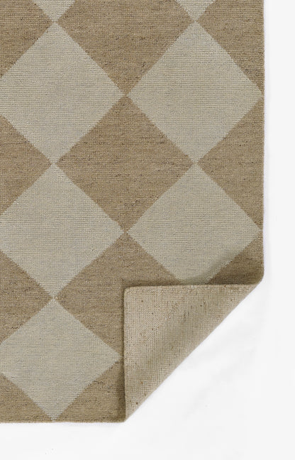 Beige and taupe argyle rug with a woven, textured fabric and large diamond pattern; folded corner shows thickness.