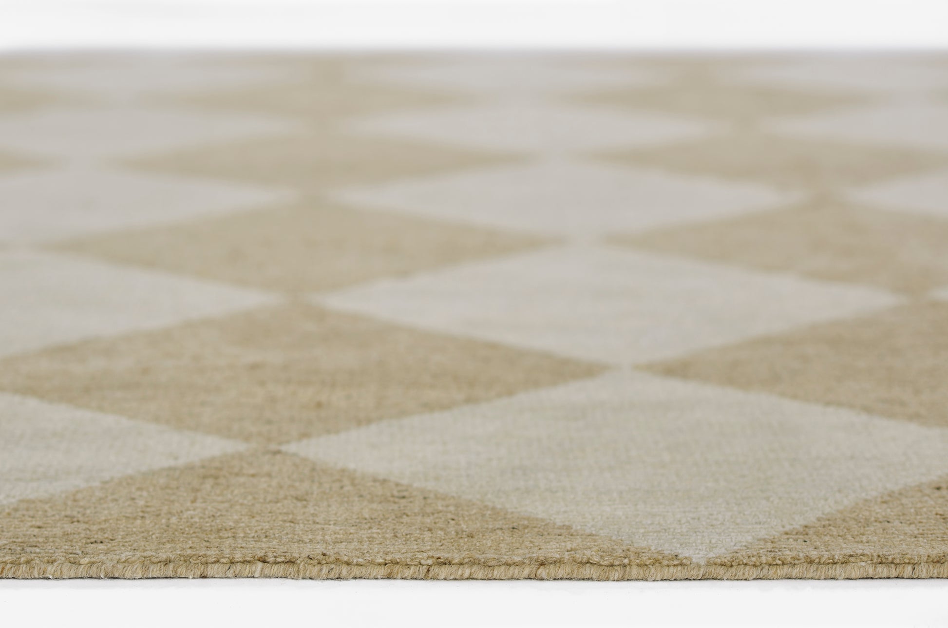 Beige and cream diamond-pattern rug with flat-weave texture; neutral geometric decor.