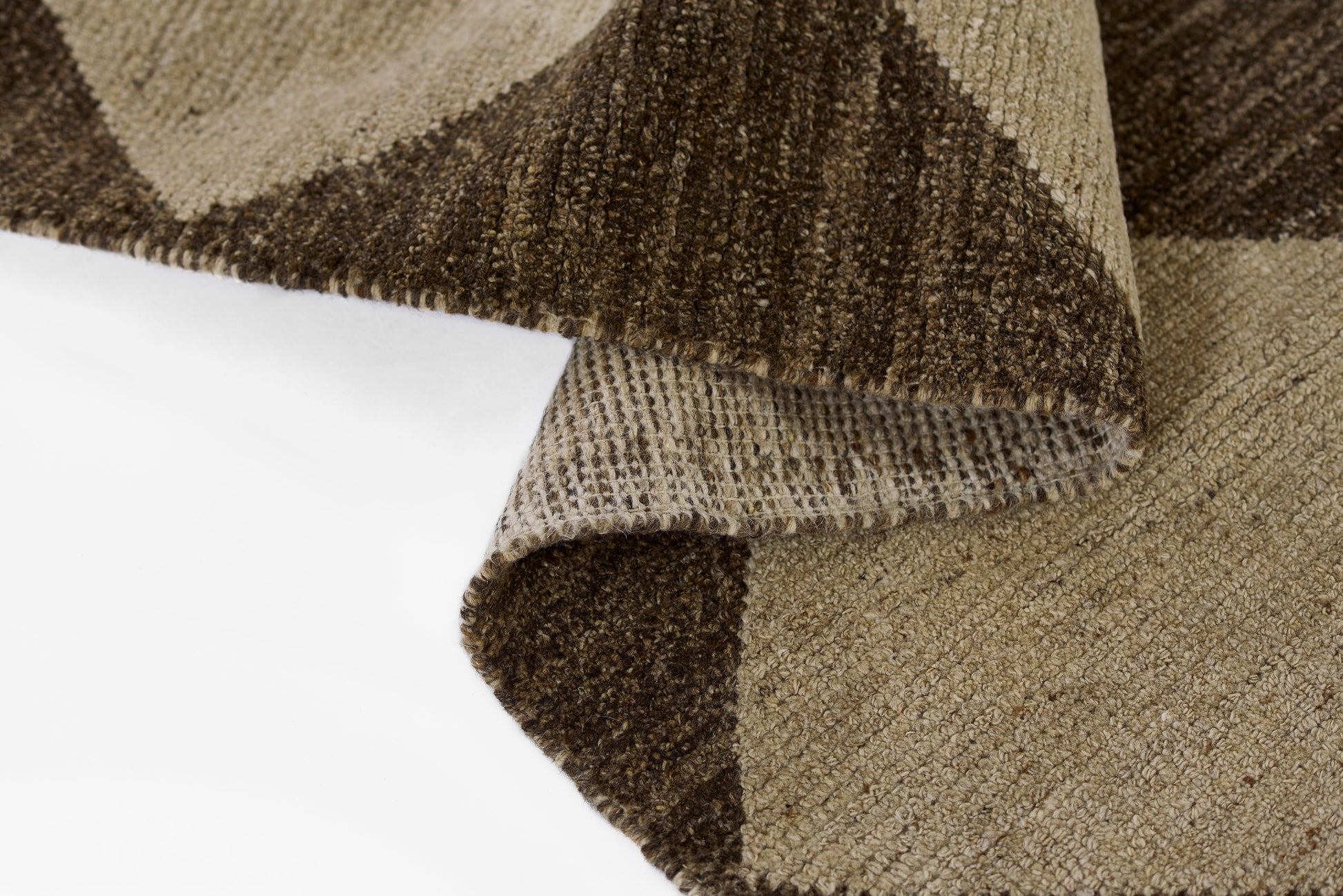 Brown and beige geometric area rug with woven texture and folded corner, modern design.