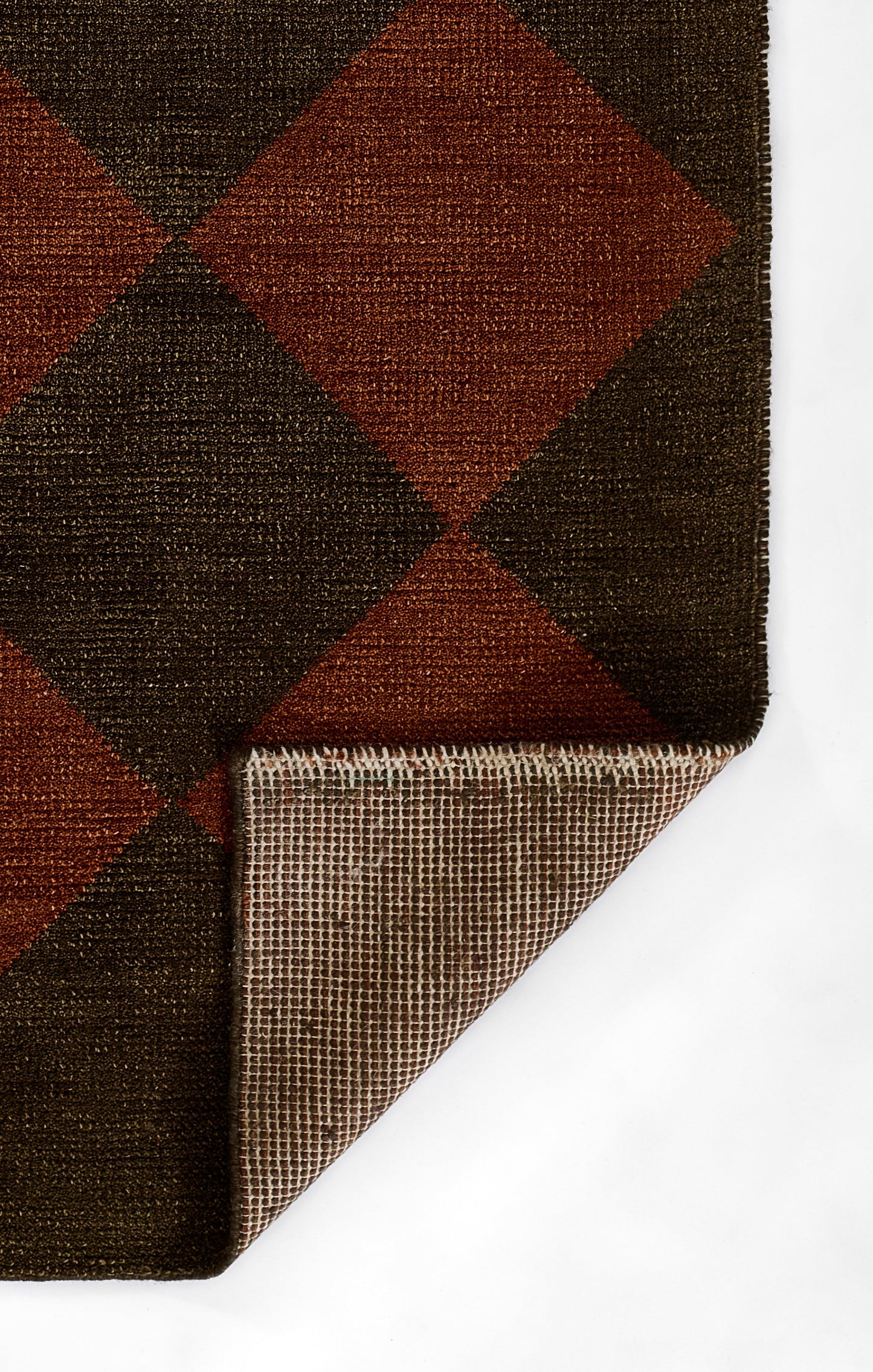 Dark brown and rust argyle wool rug with diamond pattern; folded corner reveals woven underside and edge binding