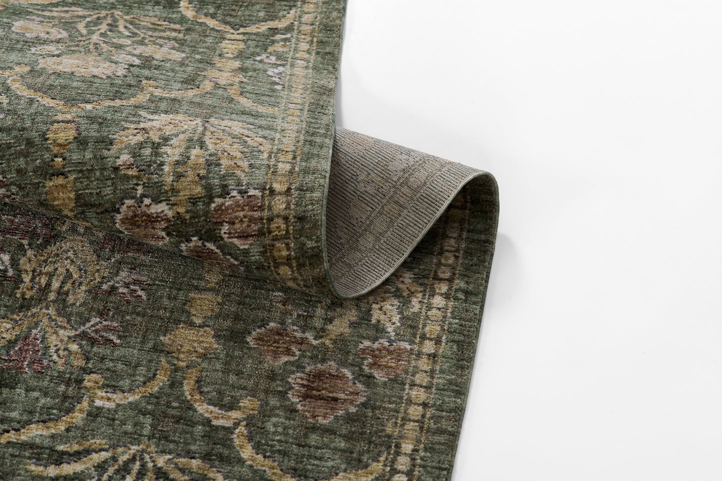 Green oriental runner rug with beige floral pattern; rolled corner reveals grey backing.