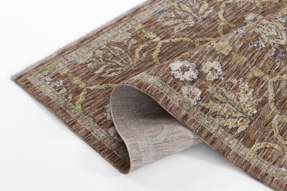 Brown floral runner rug with beige and gold accents, soft pile and curved corner exposing light gray backing.