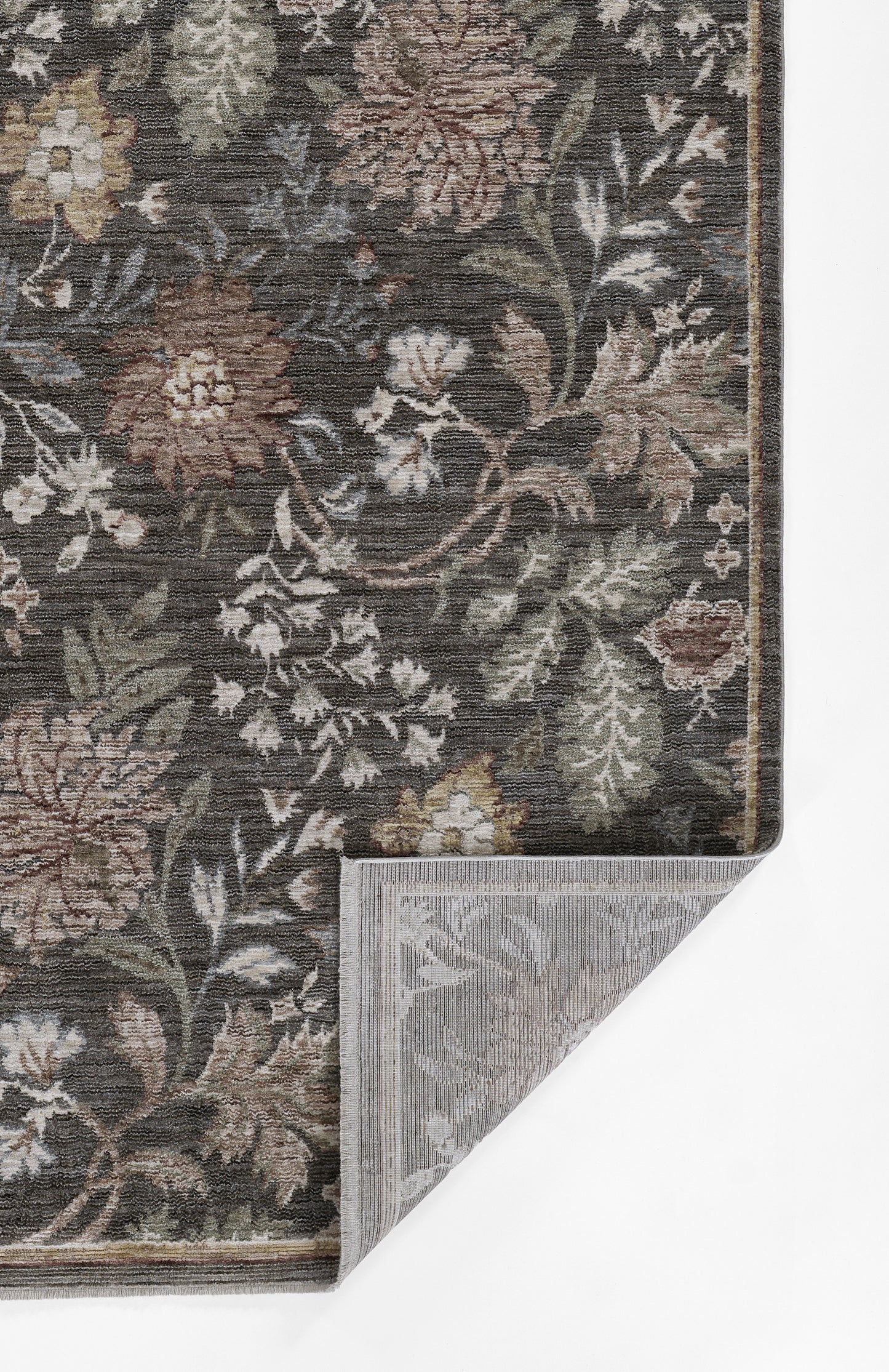 Dark floral woven rug with brown, beige, green and ivory flowers; damask pattern; folded corner reveals grey backing.
