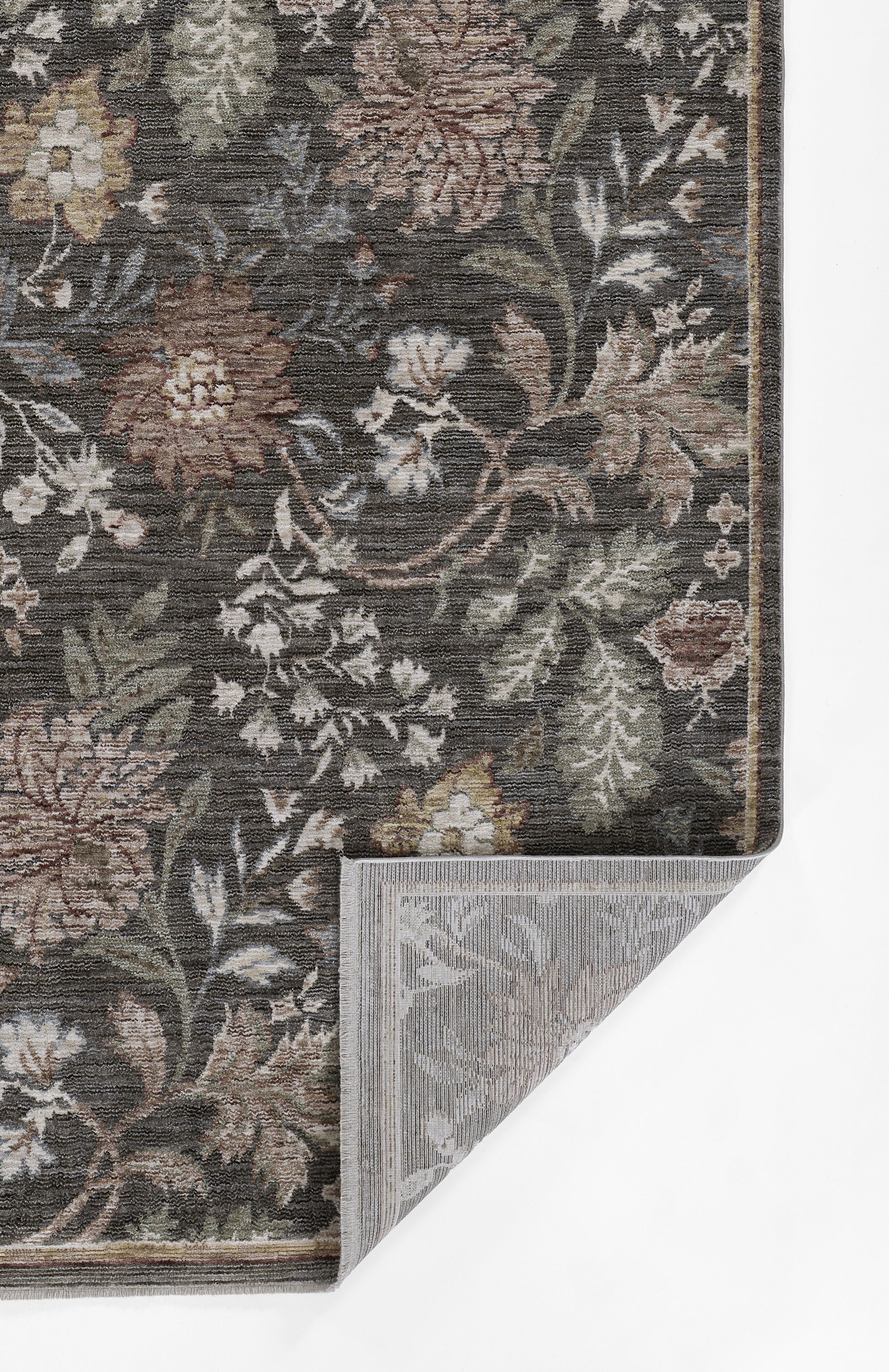 Dark floral woven rug with brown, beige, green and ivory flowers; damask pattern; folded corner reveals grey backing.
