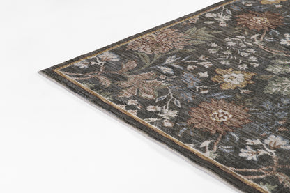 Corner of a Persian-style floral rug in muted browns, greens, and ivory; woven decorative area rug.