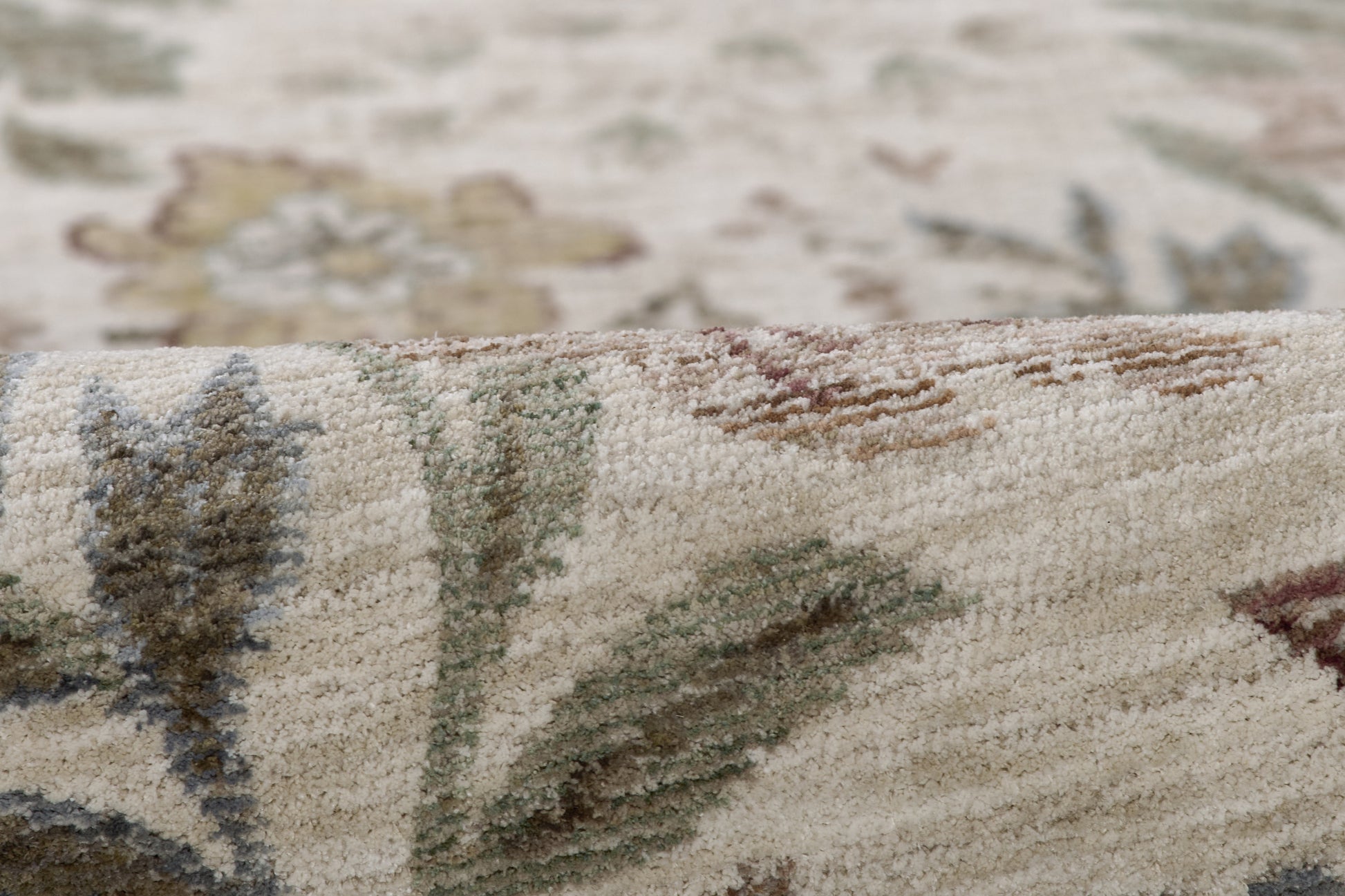 Beige woven rug with subtle floral motif in blue, green and brown; textured pile for classic oriental style.