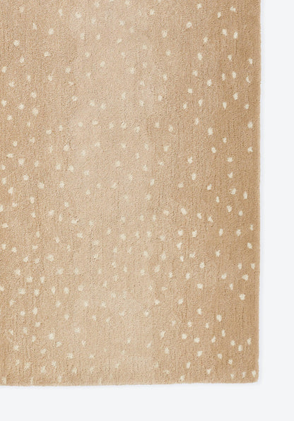 Beige speckled rug with small white dots; close-up texture with a visible edge.