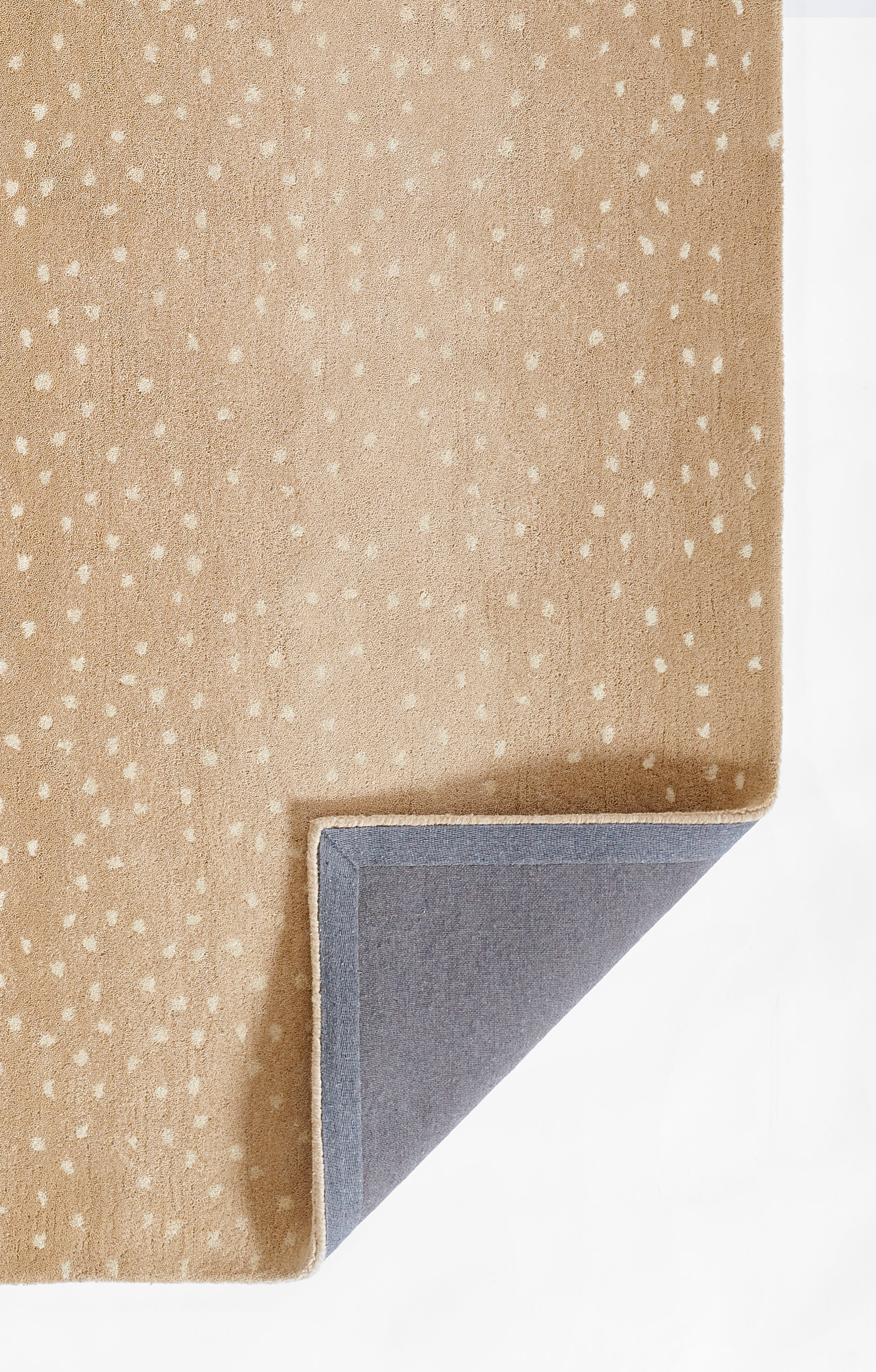 Beige rug with white speckles, soft woven texture; corner folded to reveal gray backing.