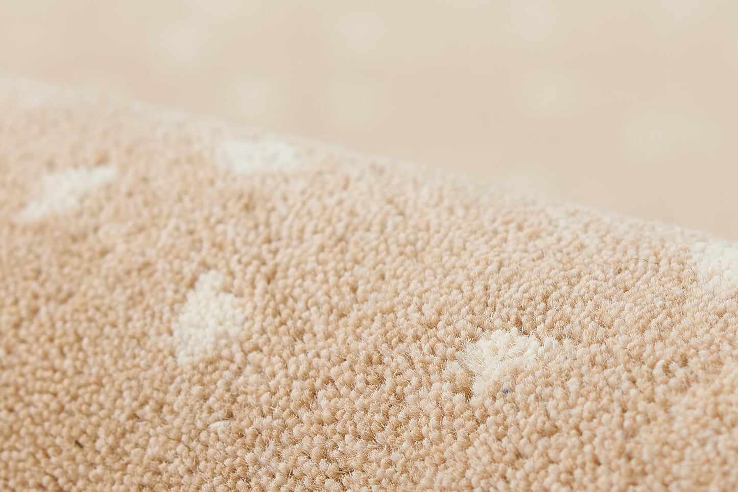 Close-up of beige rug fibers with a wood-look texture, forming a soft pile.