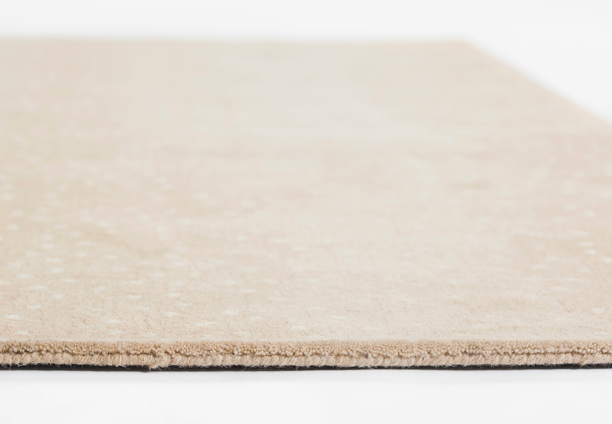 Beige rug, 2' x 3', with subtle texture.