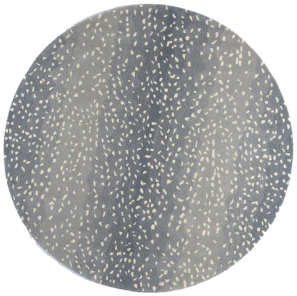 Round blue-gray placemat with irregular beige speckles, modern speckled pattern.