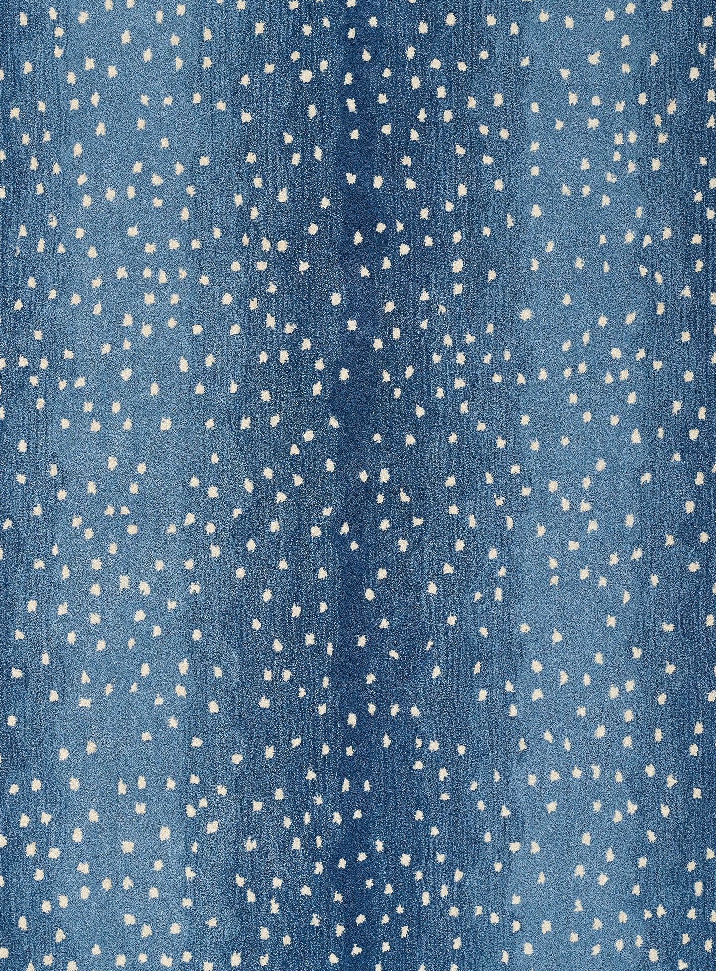 Blue rug with irregular white speckles and a dotted pattern.