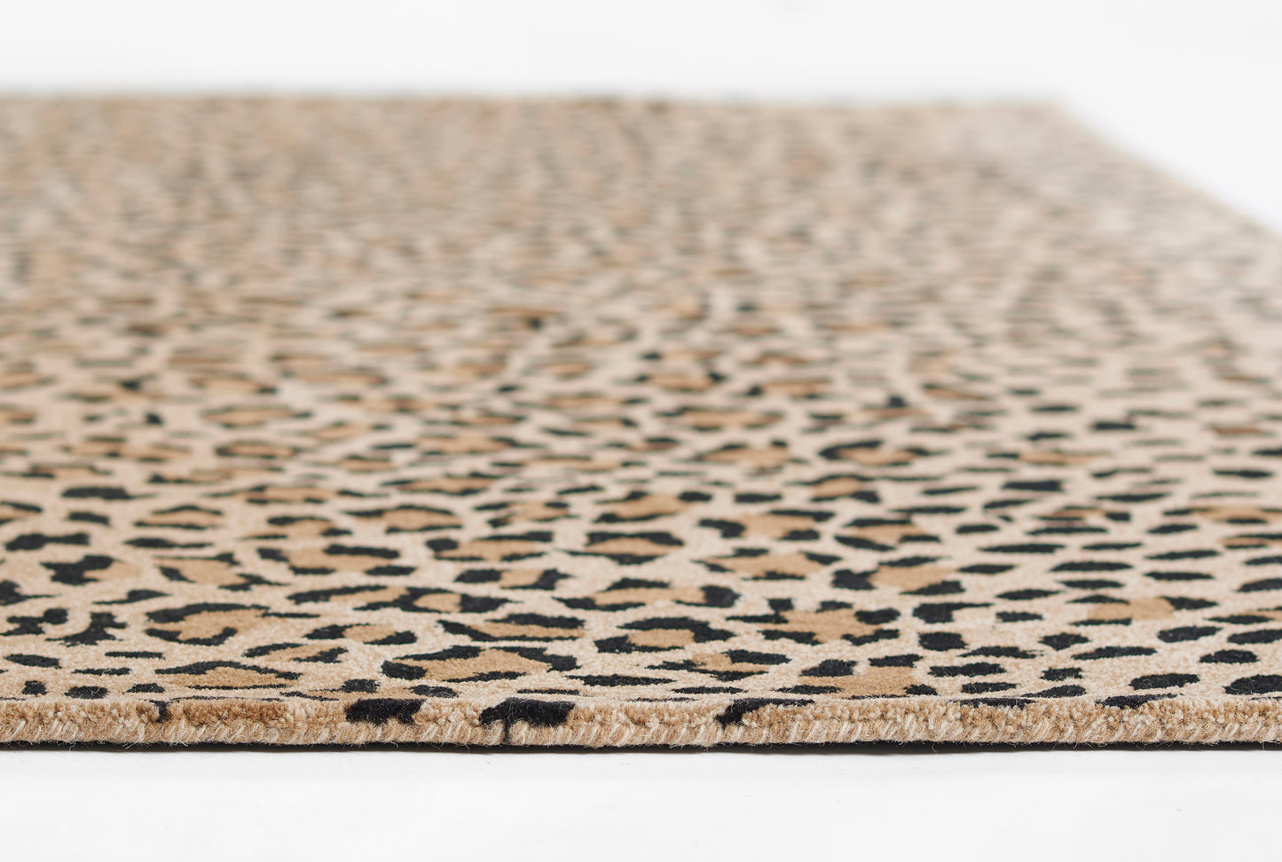 Leopard-print rug in tan and black with beige fringe along its edge.