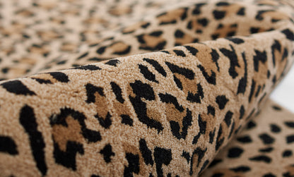 Beige leopard-print shag rug with black spots and plush pile; cozy home decor accent.
