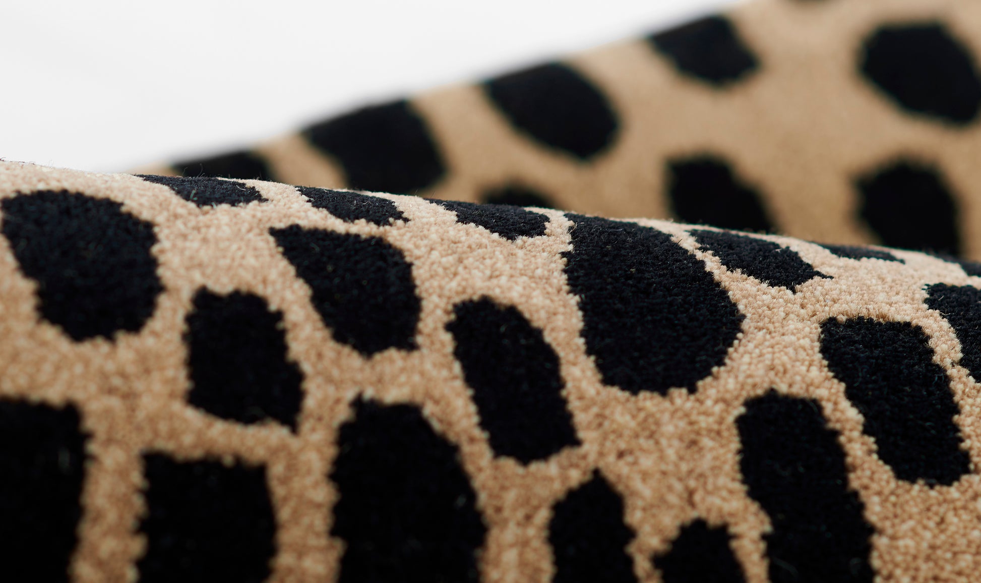 Close-up of a plush beige rug with cheetah print, soft pile and bold animal-print pattern.
