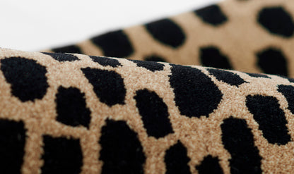 Beige leopard-print plush fabric with black irregular spots and soft pile.