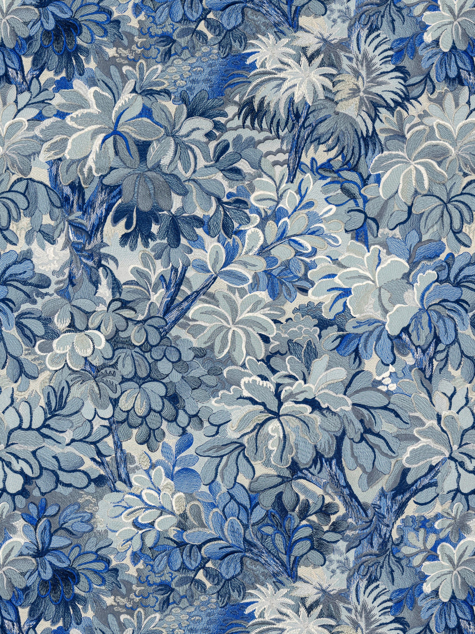 Blue botanical floral fabric with layered leaves in navy, sky blue, and gray tones; tapestry-style pattern.