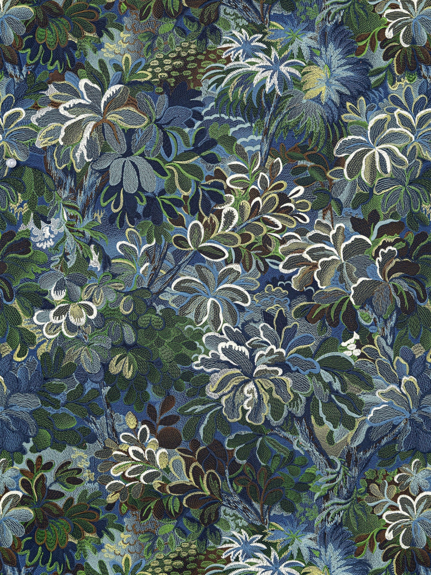 Dense tropical foliage print with blue, green and white leaves in a layered botanical pattern.