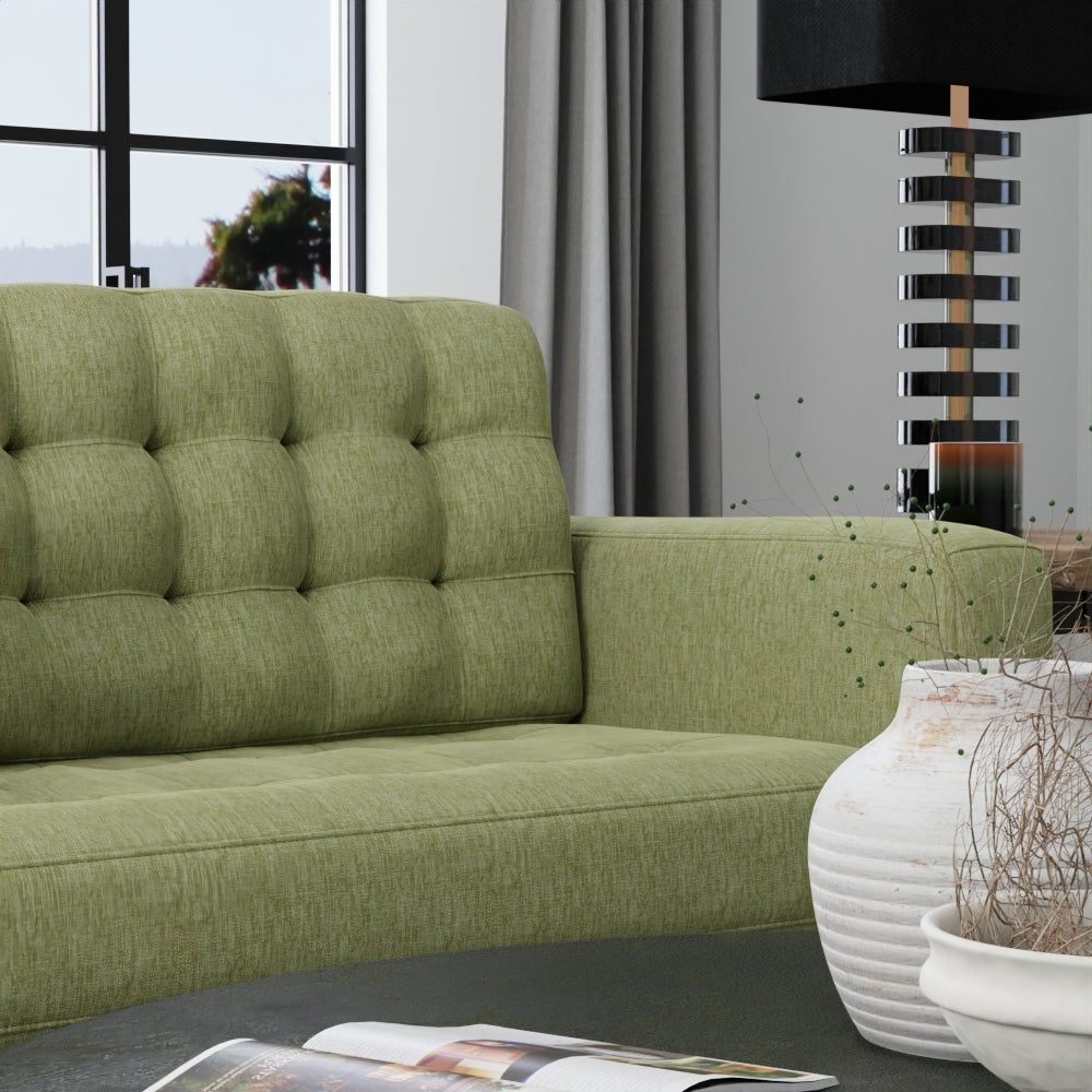 Olive-green solid fabric upholstery in a modern living room with a tall stacked-metal lamp and a white ceramic vase.
