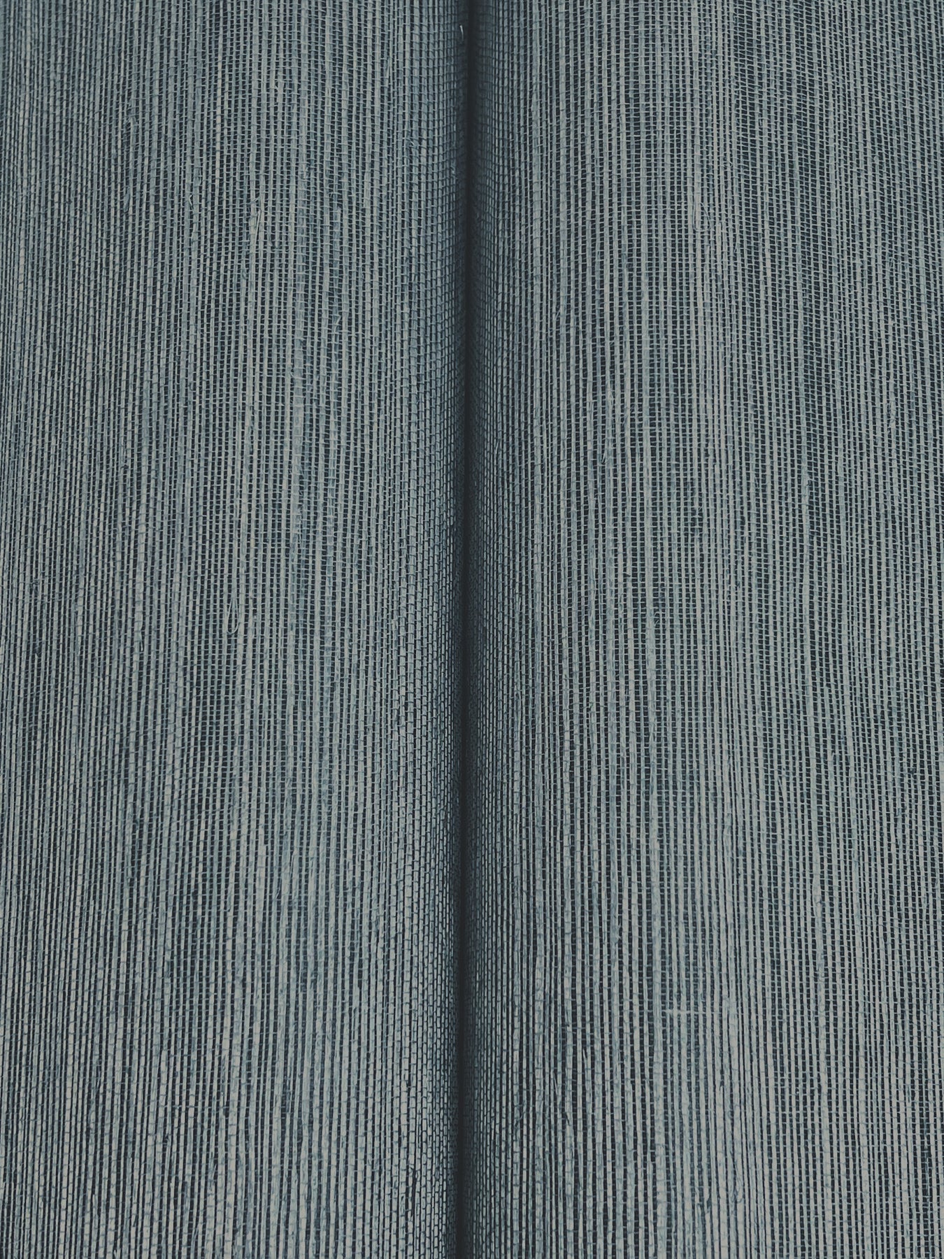 Blue-gray denim grasscloth wallpaper with a woven texture.