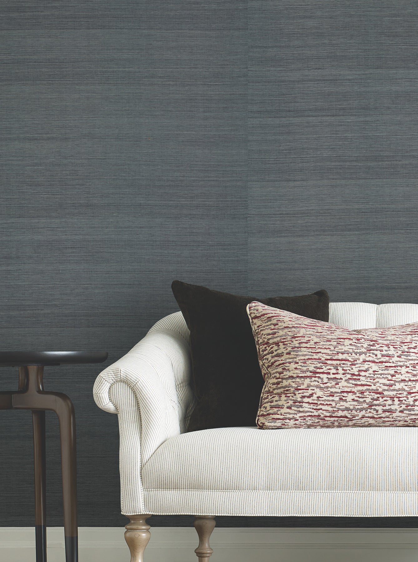 Blue-gray denim grasscloth wallpaper with a natural woven texture on the wall.