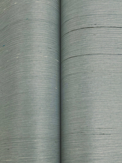 Two rolls of dusty blue wallpaper with a subtle woven texture.