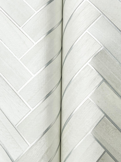 Close-up detail of pale gray herringbone wood-veneer wallpaper pattern.