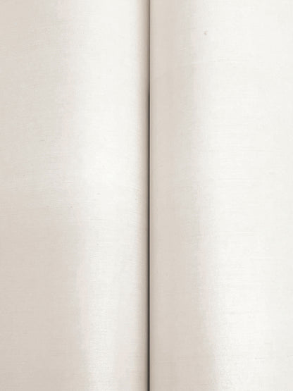 Close-up of warm beige linen-like wallpaper texture with a vertical seam between two panels.