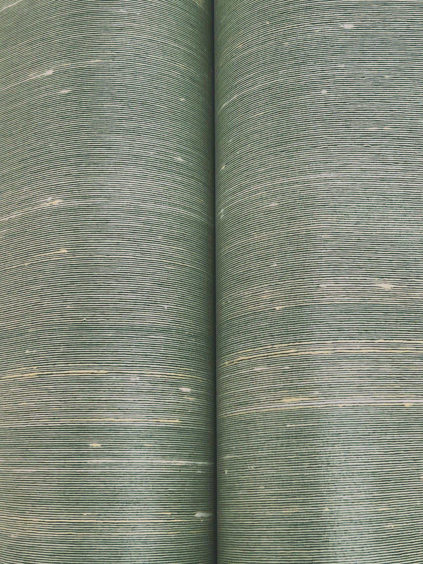 Two olive-green woven upholstery fabric rolls with fine horizontal stripes and pale flecks.