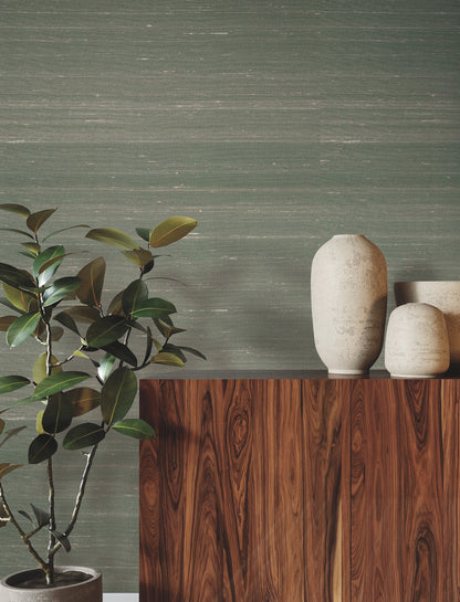 Dark walnut finish sideboard & tall ceramic vases on top, green textured wall, potted plant on left.