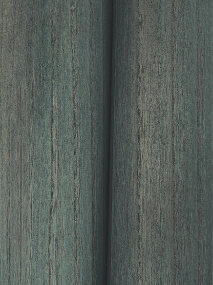 Close-up of teal wood veneer wallpaper showing weathered grain and a narrow seam.