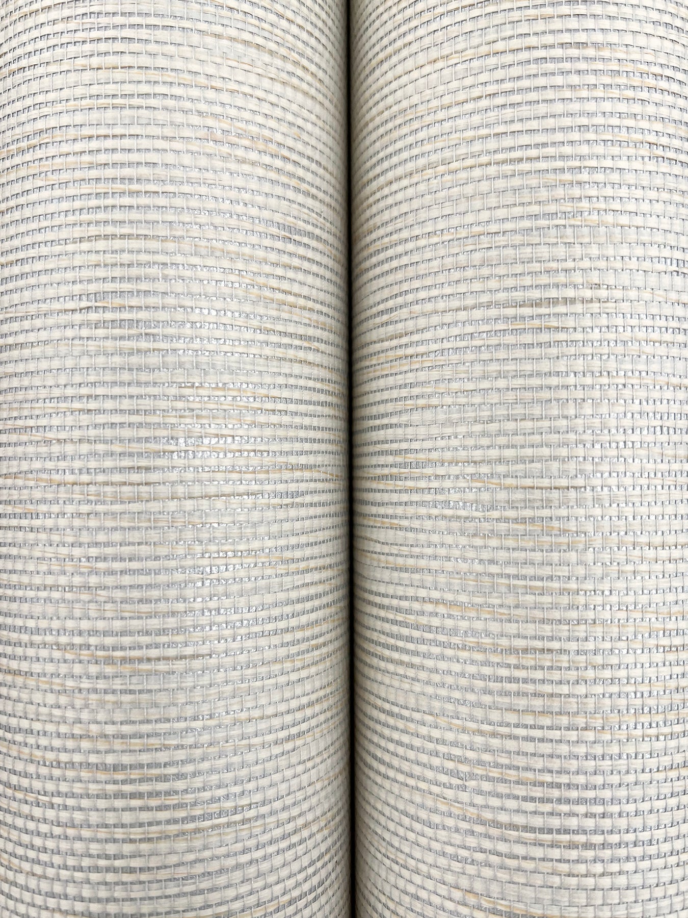 Two Oyster Pearl wallpaper rolls side by side with a textured linen-like stripe weave and subtle gray specks.