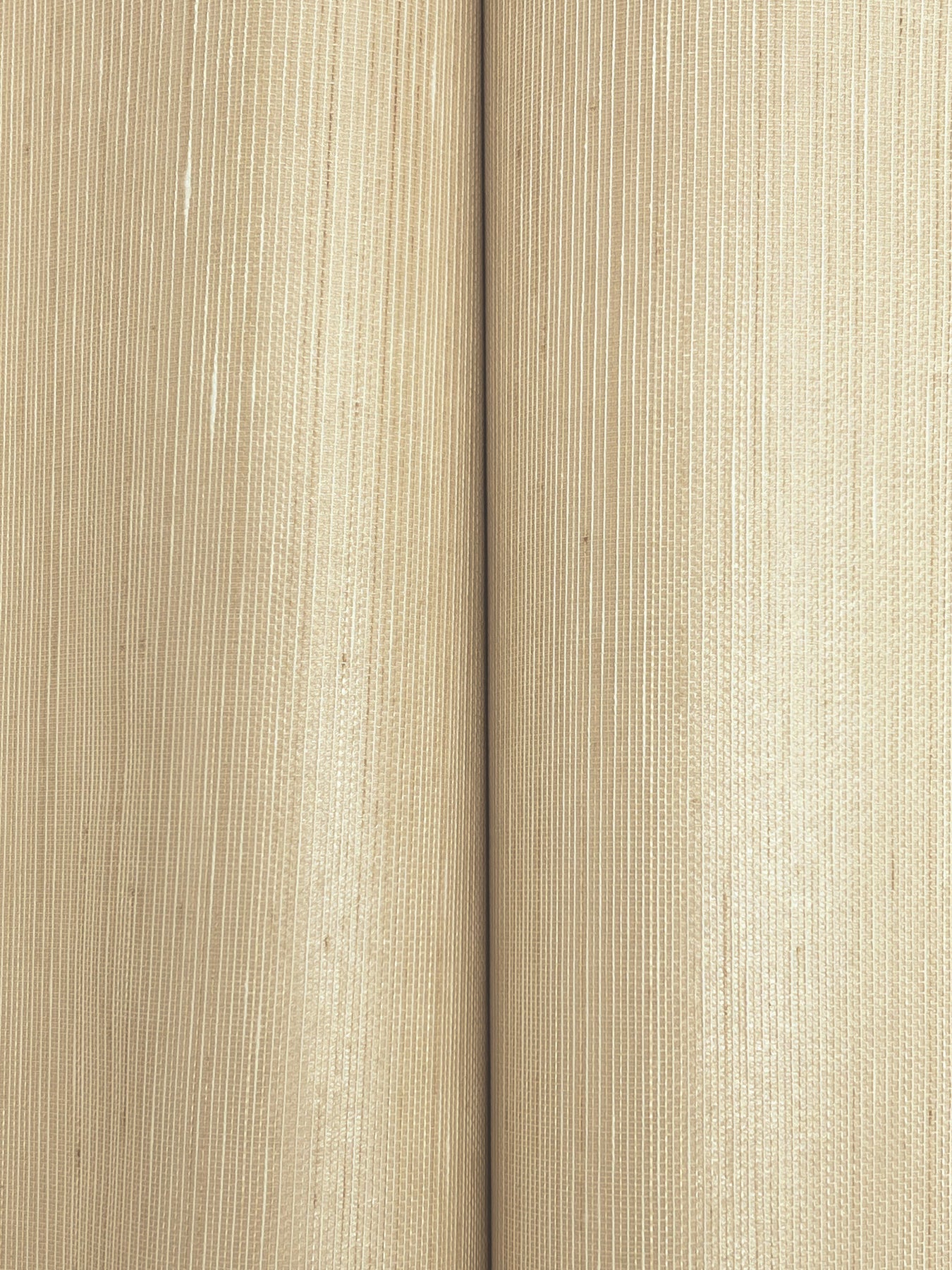 Two beige textured paper rolls side by side, close-up with subtle vertical stripes.