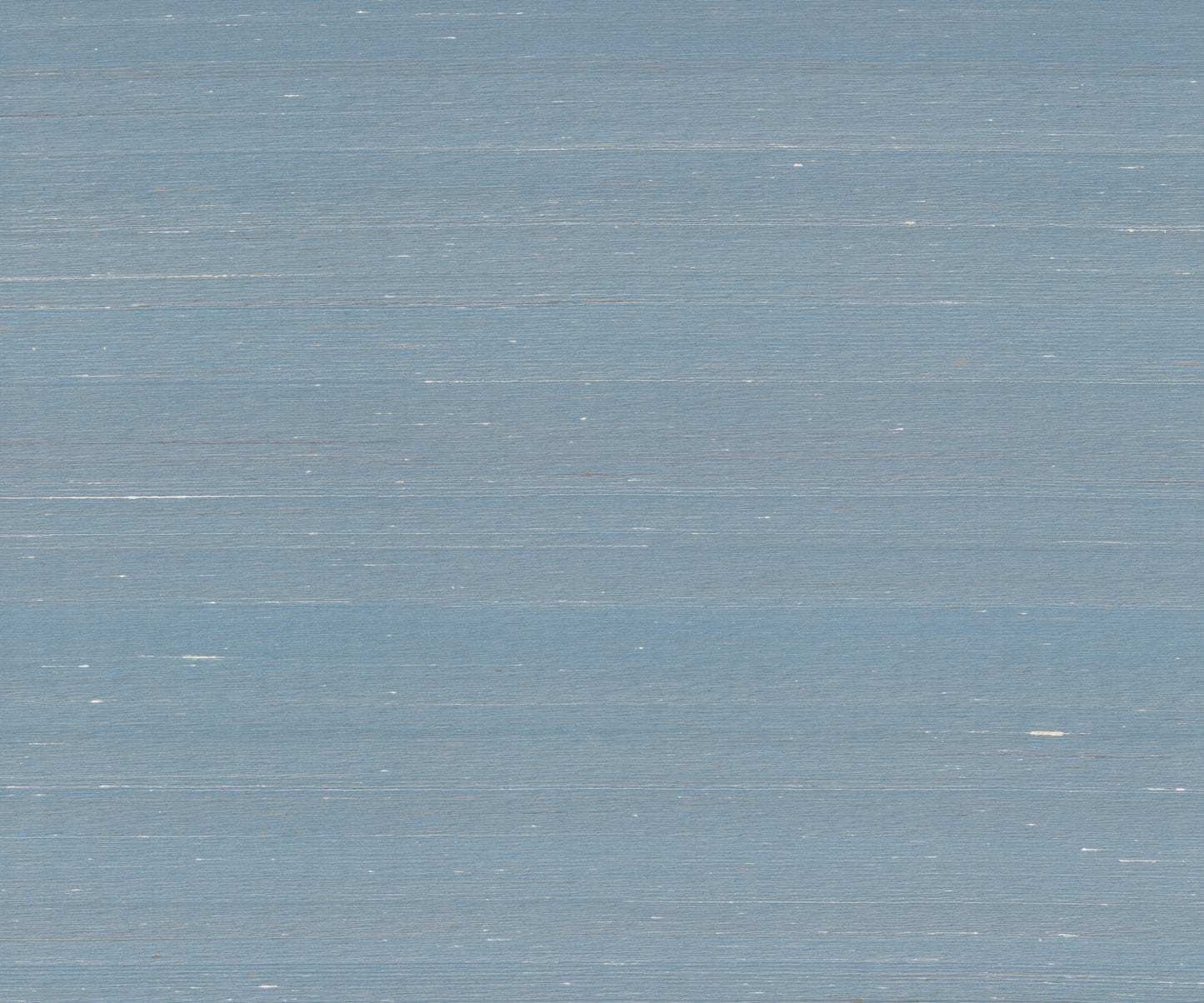Sky blue wallpaper with a subtle woven texture and light distressed marks.