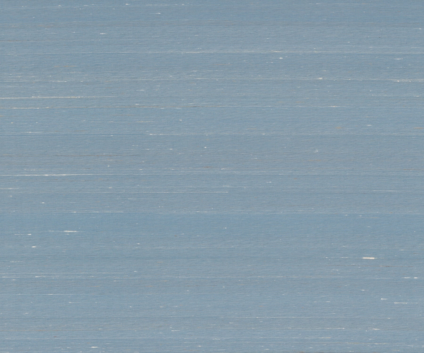 Sky blue wallpaper with a subtle woven texture and light distressed marks.