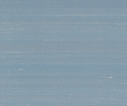 Sky blue wallpaper with a subtle woven texture and light distressed marks.
