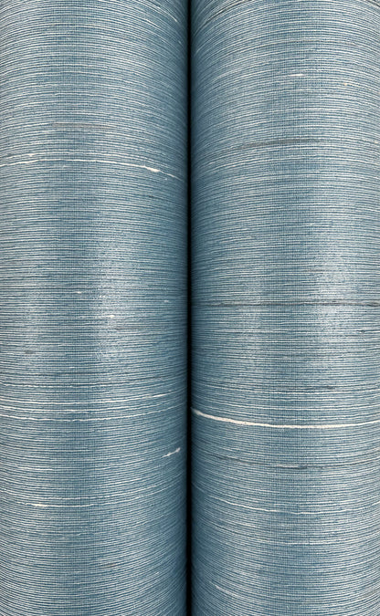 Two blue denim-like fabric rolls with fine horizontal weave and light white streaks, close-up detail.