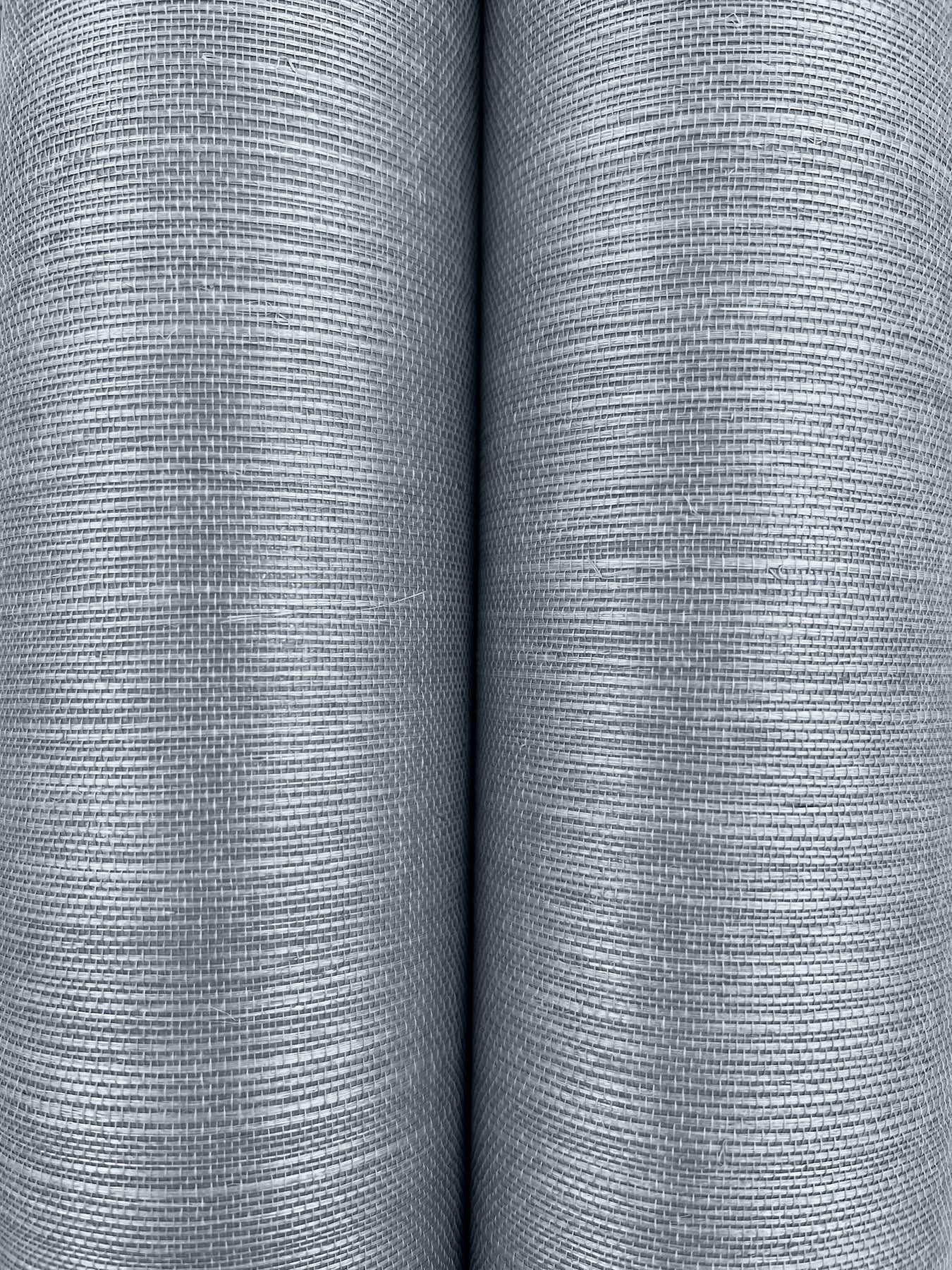 Two gray grasscloth wallpaper rolls with a fine ribbed texture and a subtle blue tint.